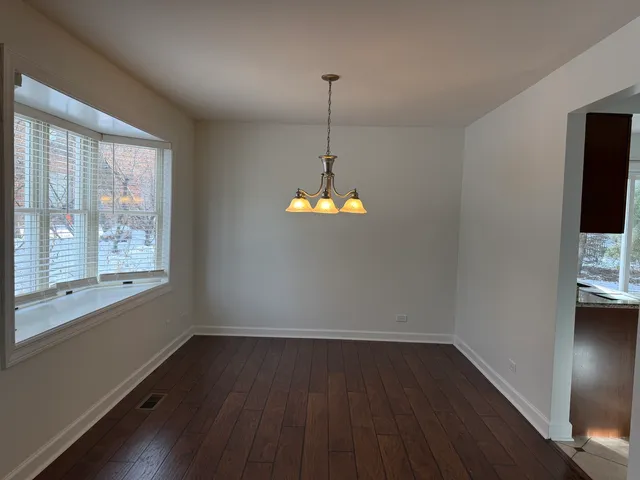 a room with wooden floor and windows