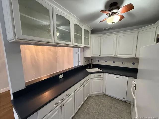 a kitchen with white cabinets and white appliances
