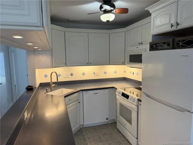 a kitchen with stainless steel appliances a refrigerator sink and cabinets