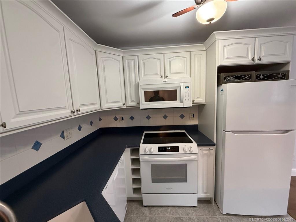 2600 Southeast Ocean Boulevard, Unit E4 Stuart, FL 34996 - Photo 6 of 47 a kitchen with white cabinets and white appliances