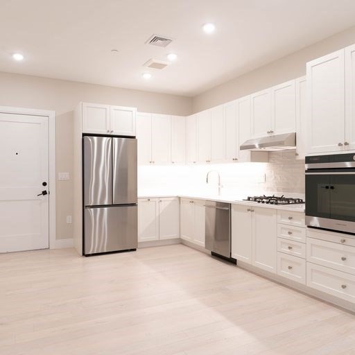 197 Green Street, Unit 202 Boston, MA 02130 - Photo 3 of 8 a kitchen with white cabinets and white appliances