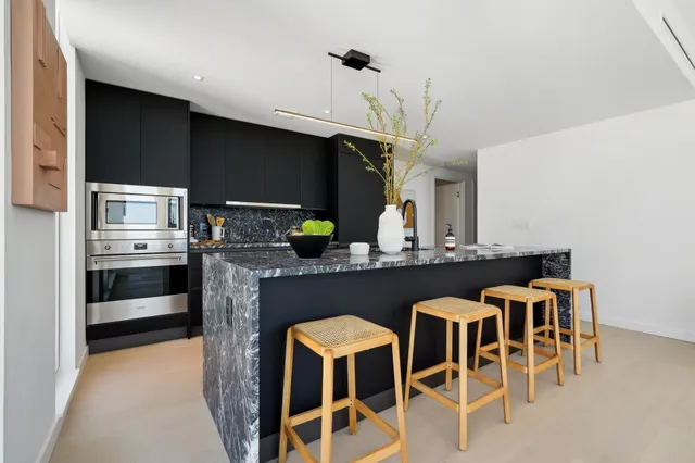 a kitchen with stainless steel appliances kitchen island granite countertop a table and chairs in it