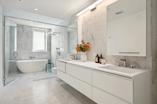 a bathroom with a double vanity sink mirror and bathtub