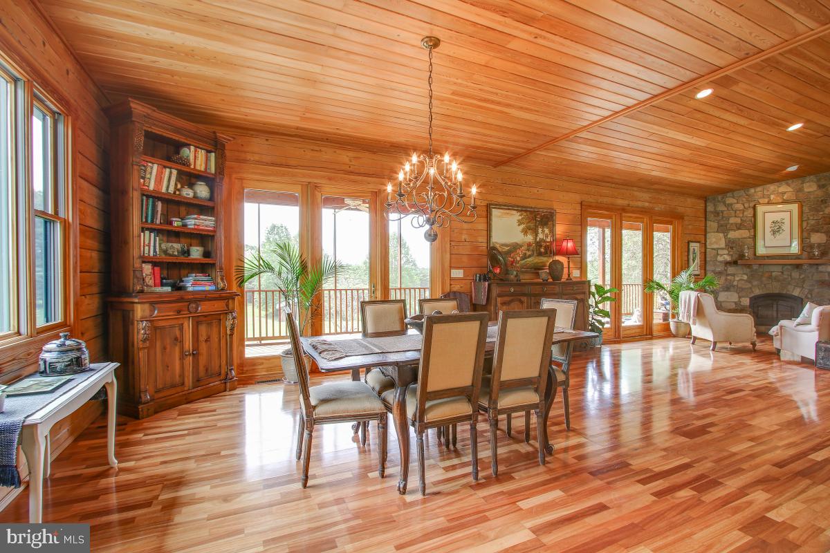 9626 Sherburne Farm Road Marshall, VA 20115 - Photo 57 of 57 a dining room with wooden floor a chandelier a glass table and chairs