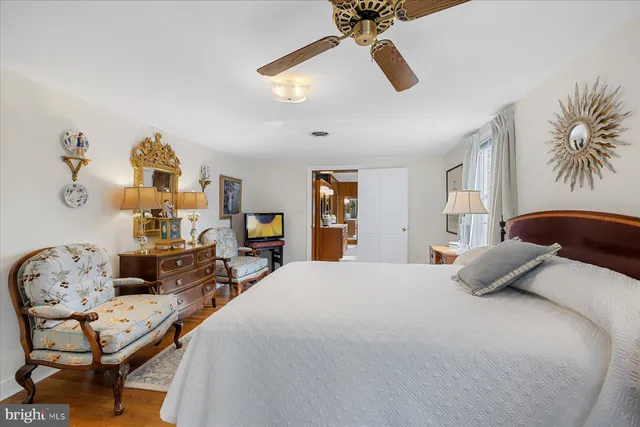 a bedroom with a bed a dresser and chair