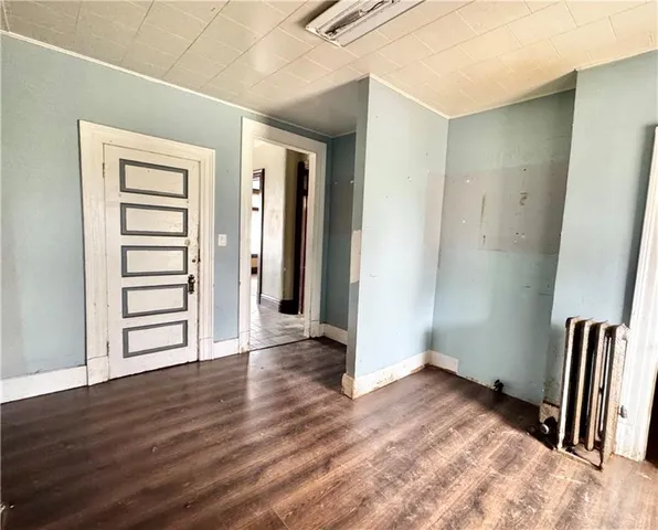 an empty room with wooden floor and stairs