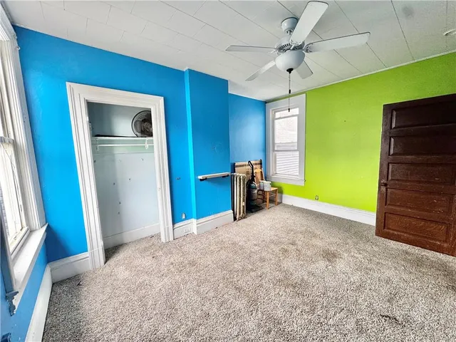 a view of an empty room with a fireplace and a window