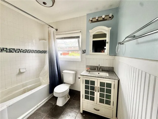 a bathroom with a toilet sink a mirror a bathtub and shower