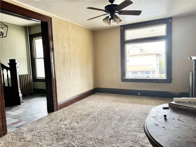 an empty room with a window and a ceiling fan