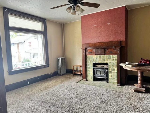 a view of an empty room with a fireplace and a window