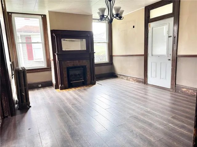 wooden floor fireplace and windows in an empty room