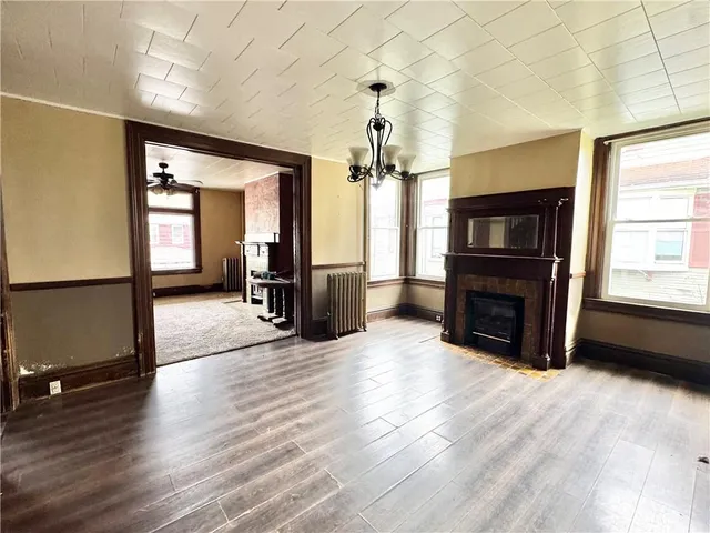wooden floor fireplace and windows in an empty room