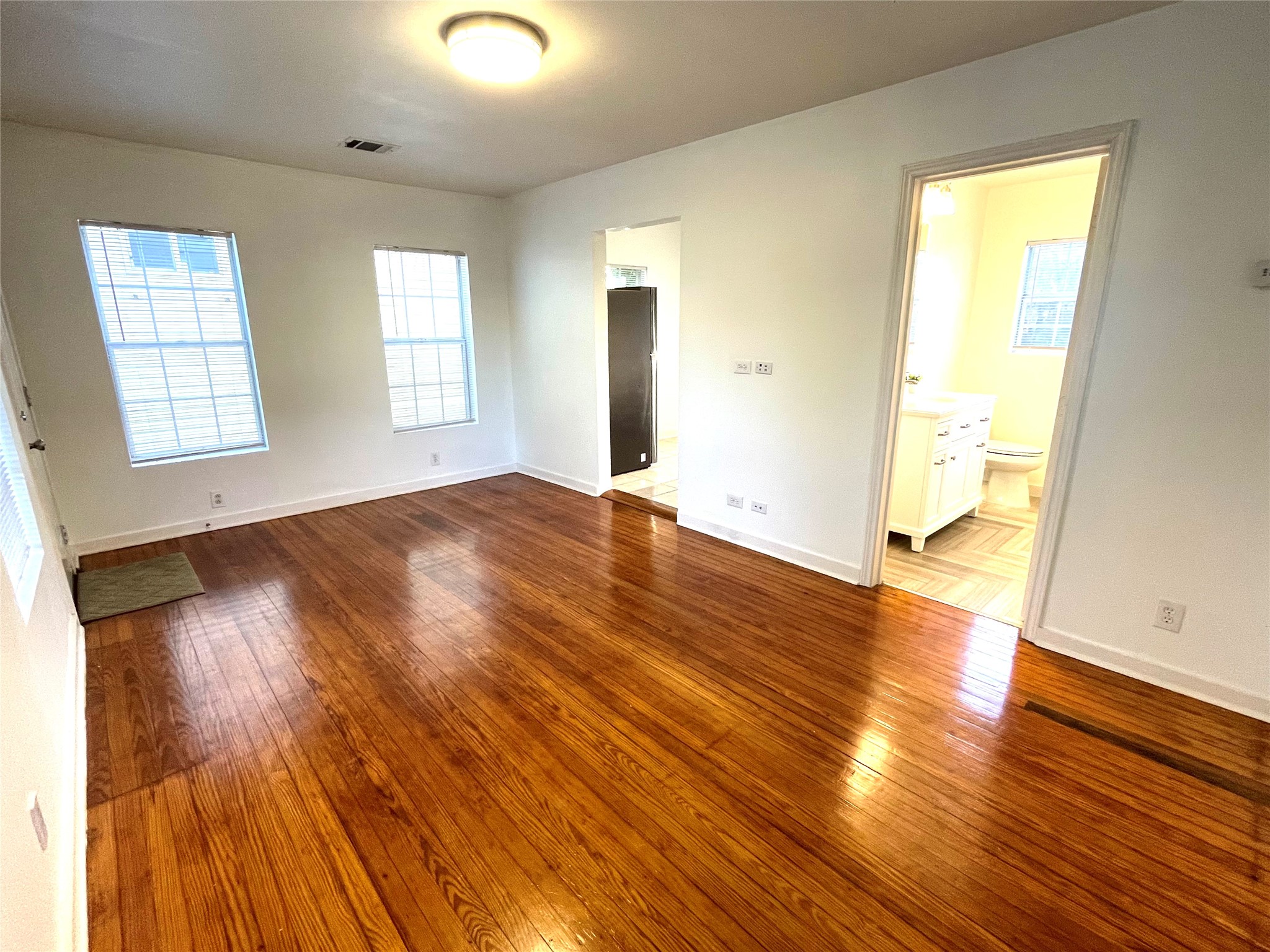 4334 Jefferson Street, Unit 1/2 Houston, TX 77023 - Photo 2 of 21 an empty room with wooden floor and windows