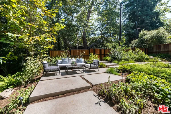 a view of a backyard with sitting area and garden