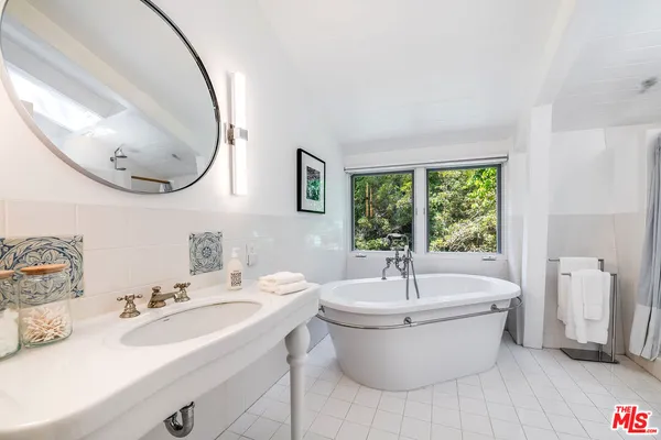 a view of a patio with table and chairs under an umbrella with wooden fence