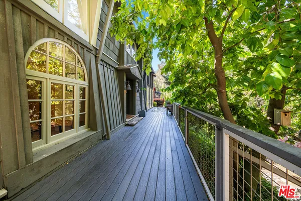 a view of a balcony with wooden floor and fence