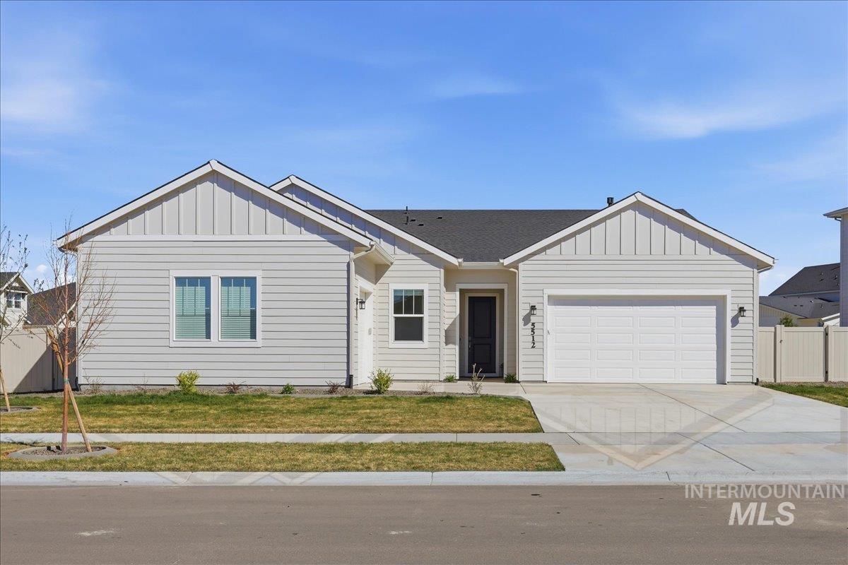 View of front of house featuring board and batten siding, an attached garage, driveway, and roof with shingles