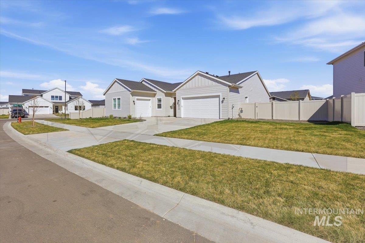 5512 North Ebony Way Meridian, ID 83646 - Photo 2 of 40 View of front of home with a residential view, an attached garage, concrete driveway, board and batten siding, and a gate