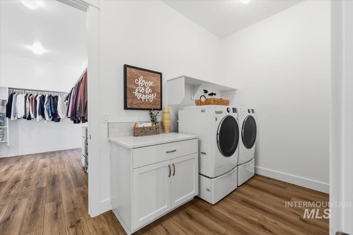 5512 North Ebony Way Meridian, ID 83646 - Photo 24 of 40 Laundry room with dark wood-type flooring, separate washer and dryer, and cabinet space