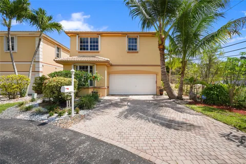 a view of a house with a yard and palm trees