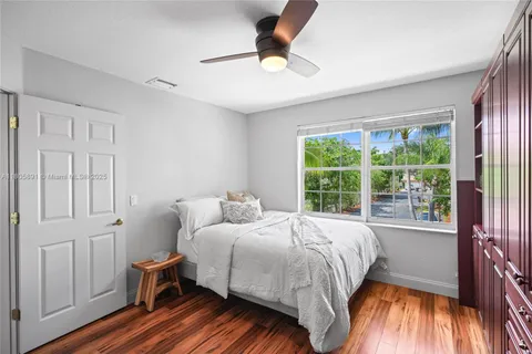 a bedroom with a bed a flat screen tv and a chandelier