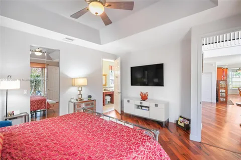 a view of a hallway with wooden floor and living room