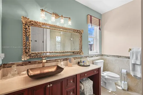 a kitchen with stainless steel appliances granite countertop a refrigerator a sink dishwasher and wooden cabinets with wooden floor