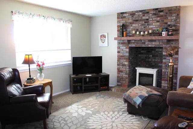 a living room with furniture a flat screen tv and a fireplace