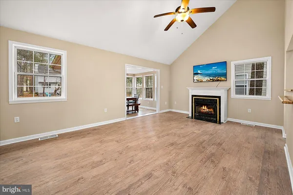 a kitchen with stainless steel appliances granite countertop a stove top oven a sink dishwasher and white cabinets with wooden floor