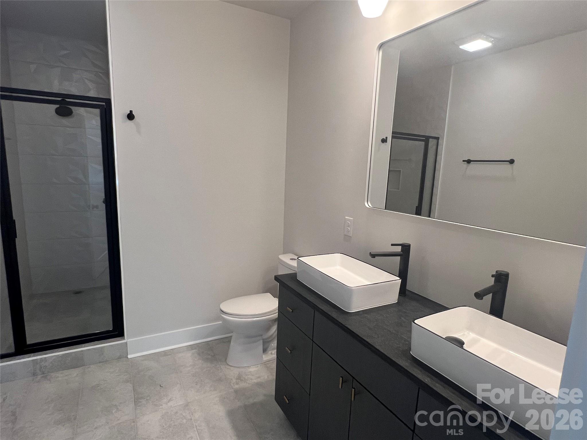 1356 Briar Creek Road Charlotte, NC 28205 - Photo 3 of 15 a bathroom with a sink a toilet and mirror