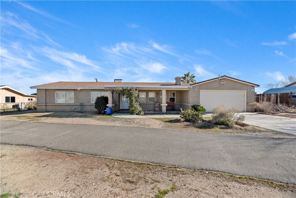 14745 Manzano Road Victorville, CA 92392 - Photo 1 of 1 a front view of a house with a yard and garage