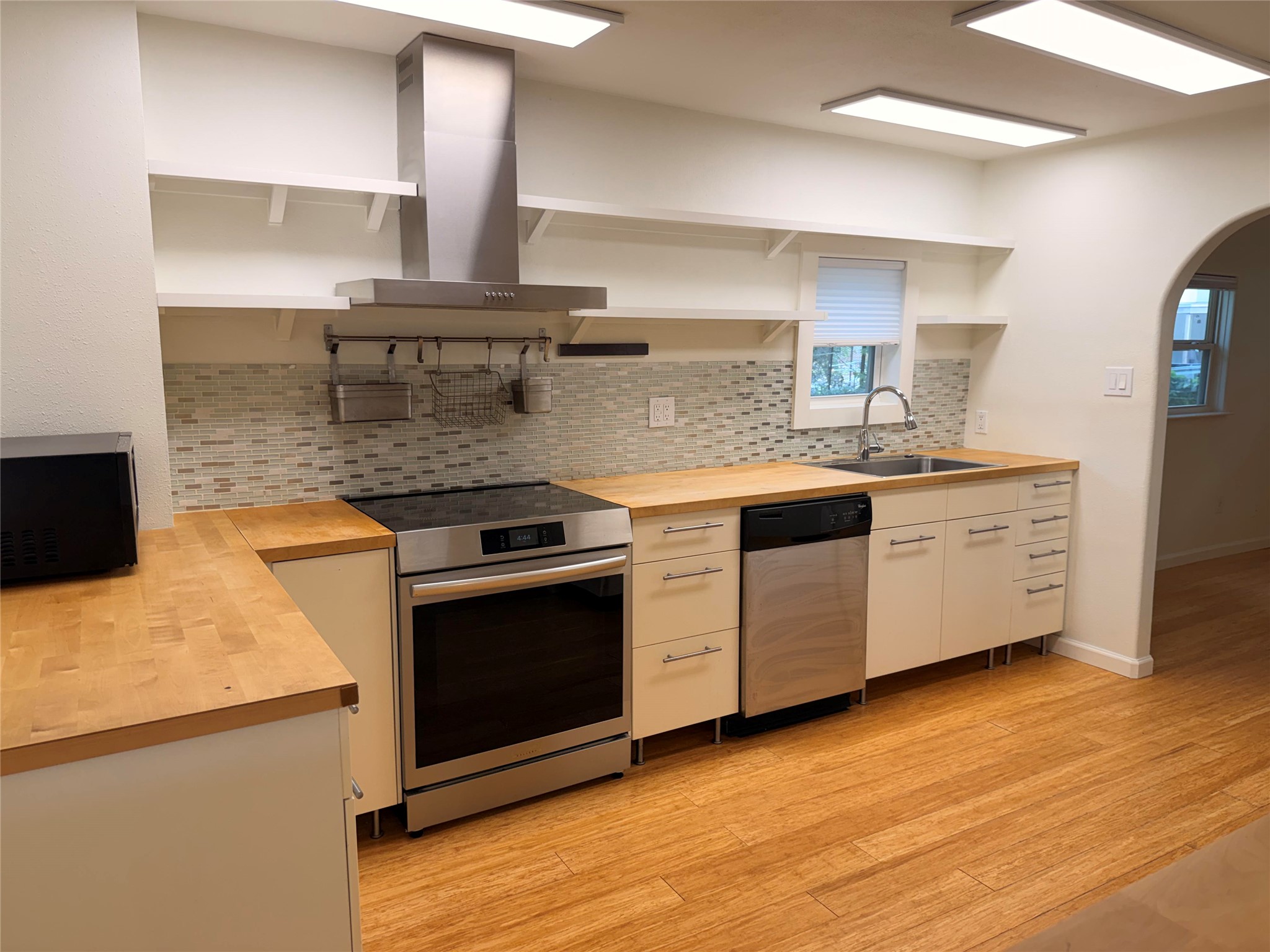 1182 Pandora Street Austin, TX 78702 - Photo 7 of 19 Bright, airy kitchen showcasing light wood flooring and sleek stainless steel appliances.