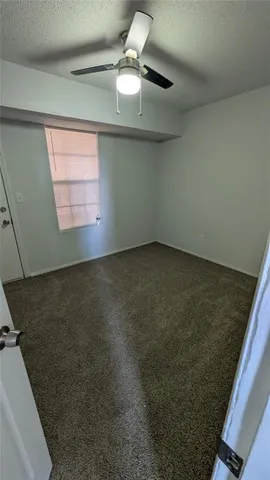 en empty room with windows and ceiling fan