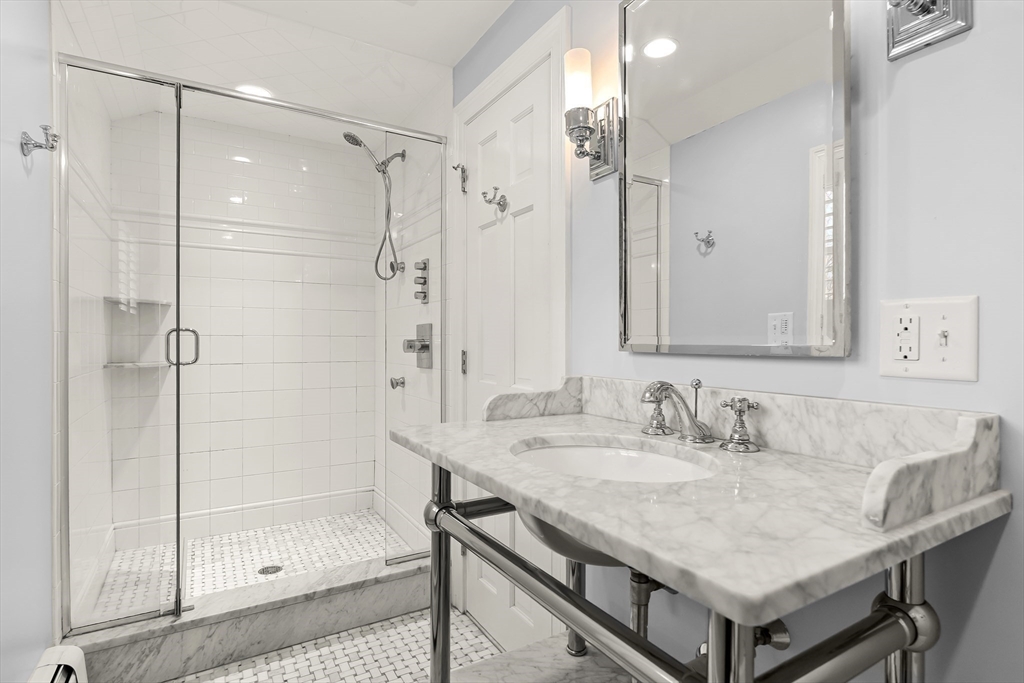 27 Radcliffe Road Wellesley, MA 02482 - Photo 26 of 38 a bathroom with a shower sink and mirror