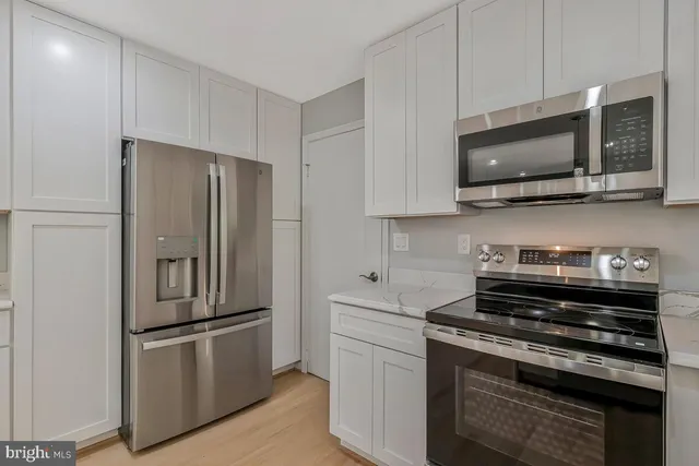 a kitchen with stainless steel appliances a refrigerator stove and microwave