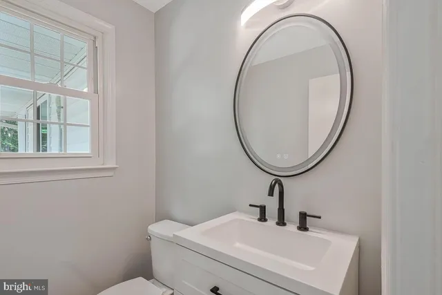 a bathroom with a sink a toilet and a mirror