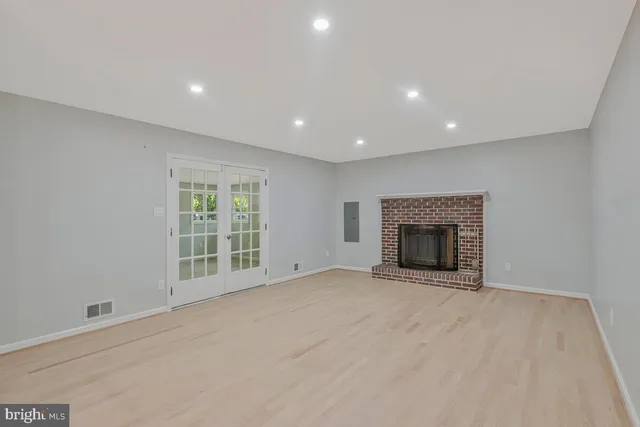 a view of an empty room with a fireplace and a window