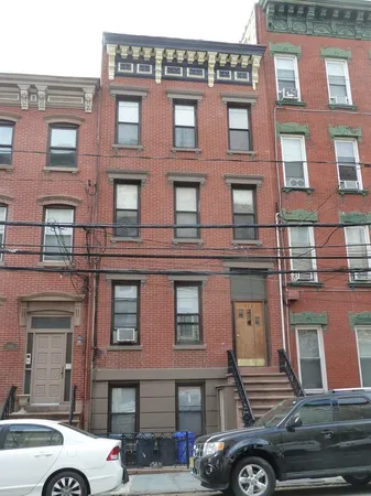 a front view of a building with car parked