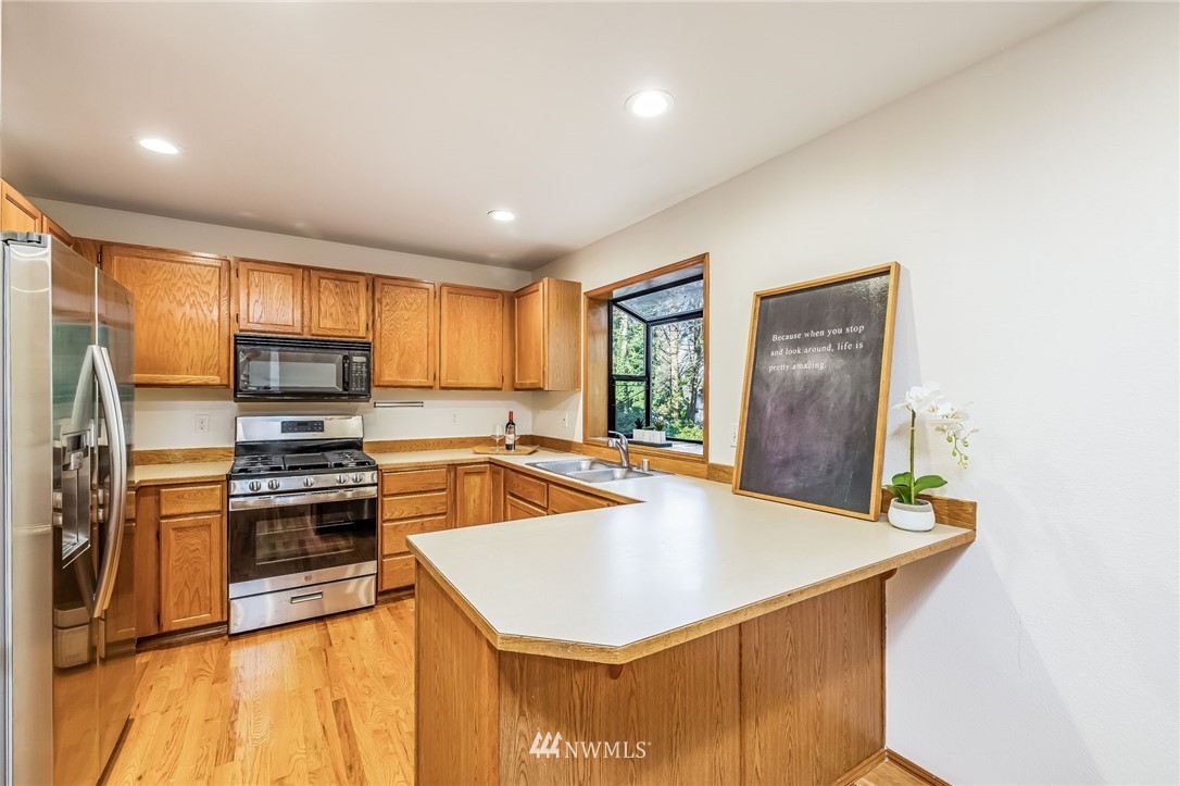 23511 Meridian Avenue South Bothell, WA 98021 - Photo 17 of 40 a kitchen with stainless steel appliances a stove top oven a sink a refrigerator a window