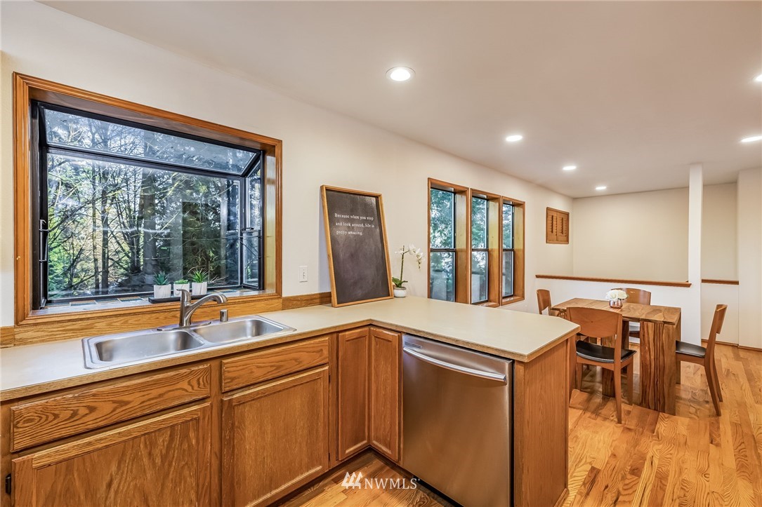 23511 Meridian Avenue South Bothell, WA 98021 - Photo 18 of 40 a open kitchen with stainless steel appliances granite countertop a sink and dishwasher with a dining table