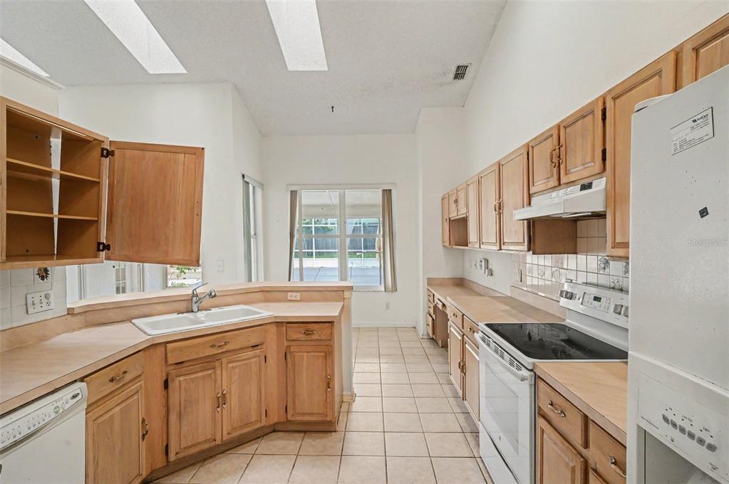 4716 Spaniel Street Orlando, FL 32818 - Photo 7 of 27 a kitchen with a sink stove and cabinets