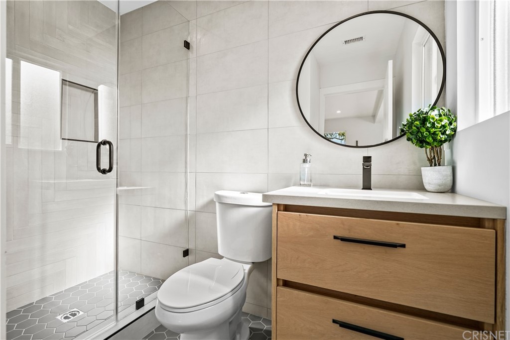 3675 Denair Street Pasadena, CA 91107 - Photo 28 of 37 a bathroom with a sink a mirror a toilet and a shower