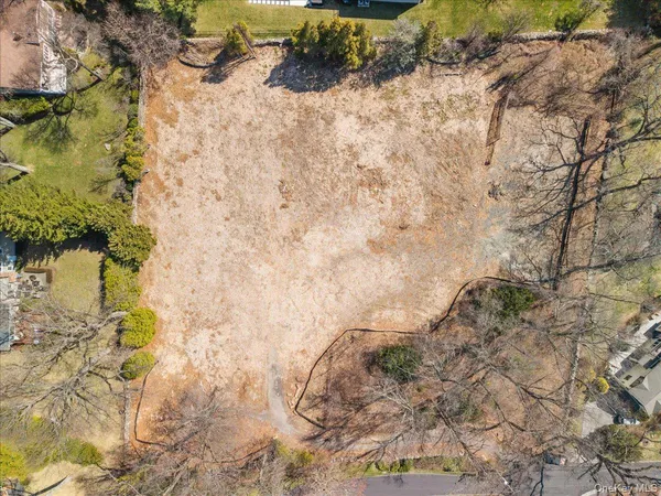 a view of a dry yard with wooden fence