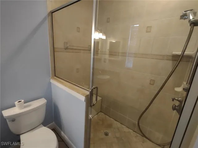 a bathroom with a granite countertop sink a toilet and shower