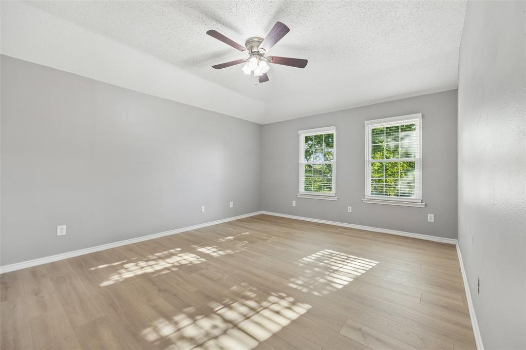 753 Summerfield Drive Allen, TX 75002 - Photo 27 of 40 Spacious room featuring light wood-finish flooring, two large windows with white blinds, and a ceiling fan with integrated lighting