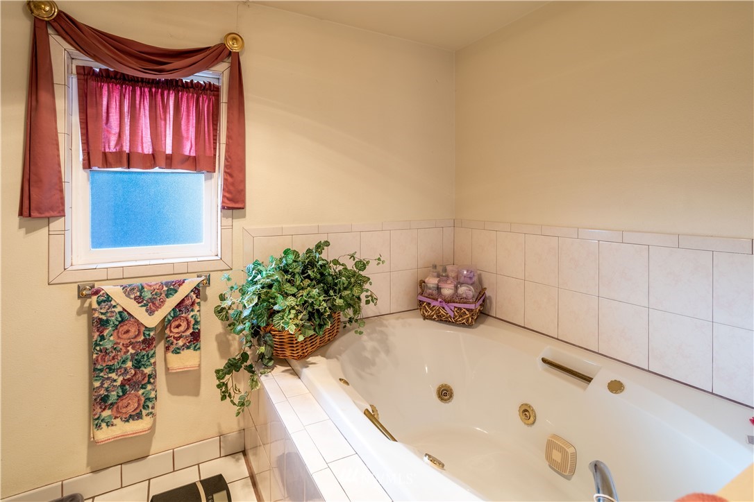 18703 Joselyn Road Southwest Rochester, WA 98579 - Photo 11 of 40 a bathroom with a tub and a window