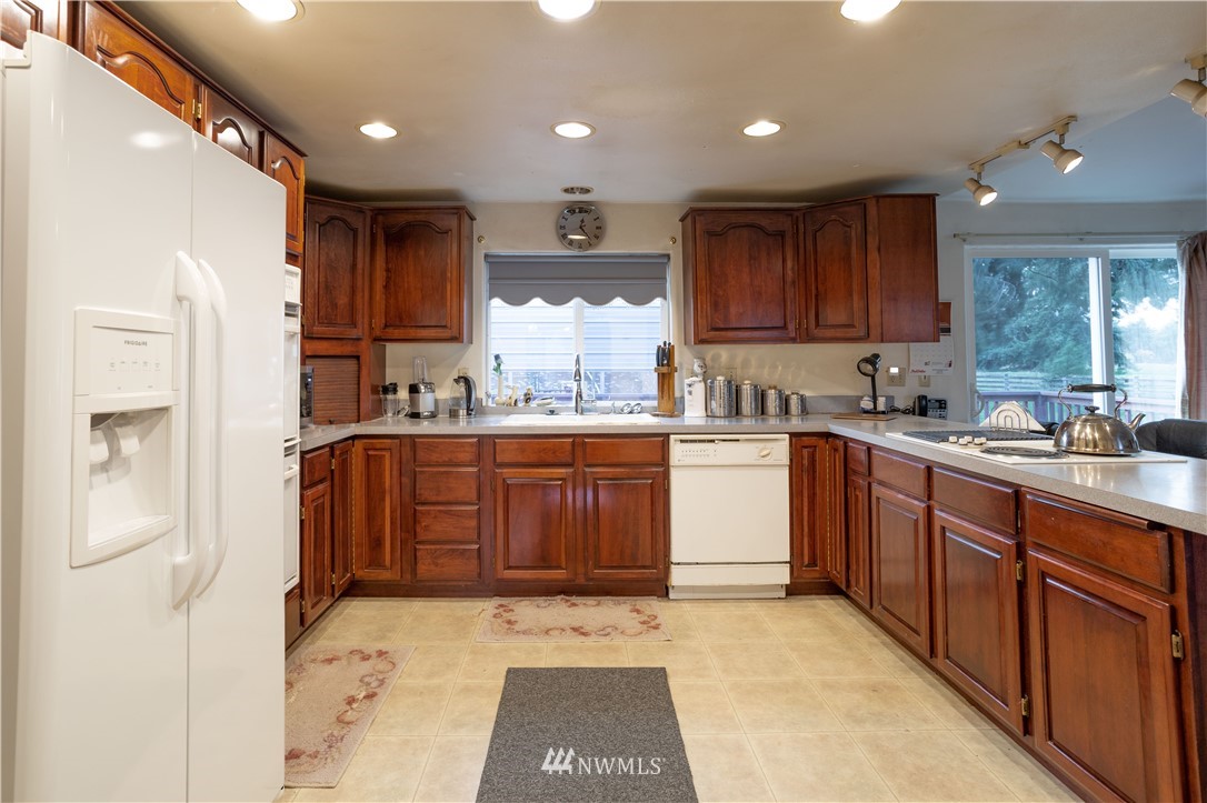 18703 Joselyn Road Southwest Rochester, WA 98579 - Photo 3 of 40 a kitchen with a sink refrigerator and cabinets