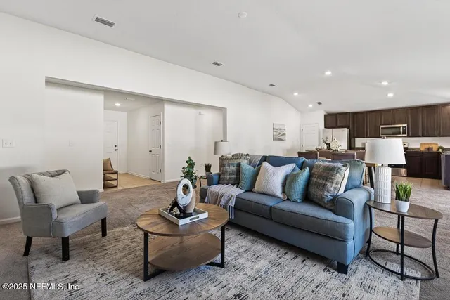 a living room with furniture and kitchen view