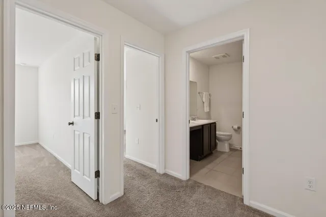 a view of a hallway with bathroom