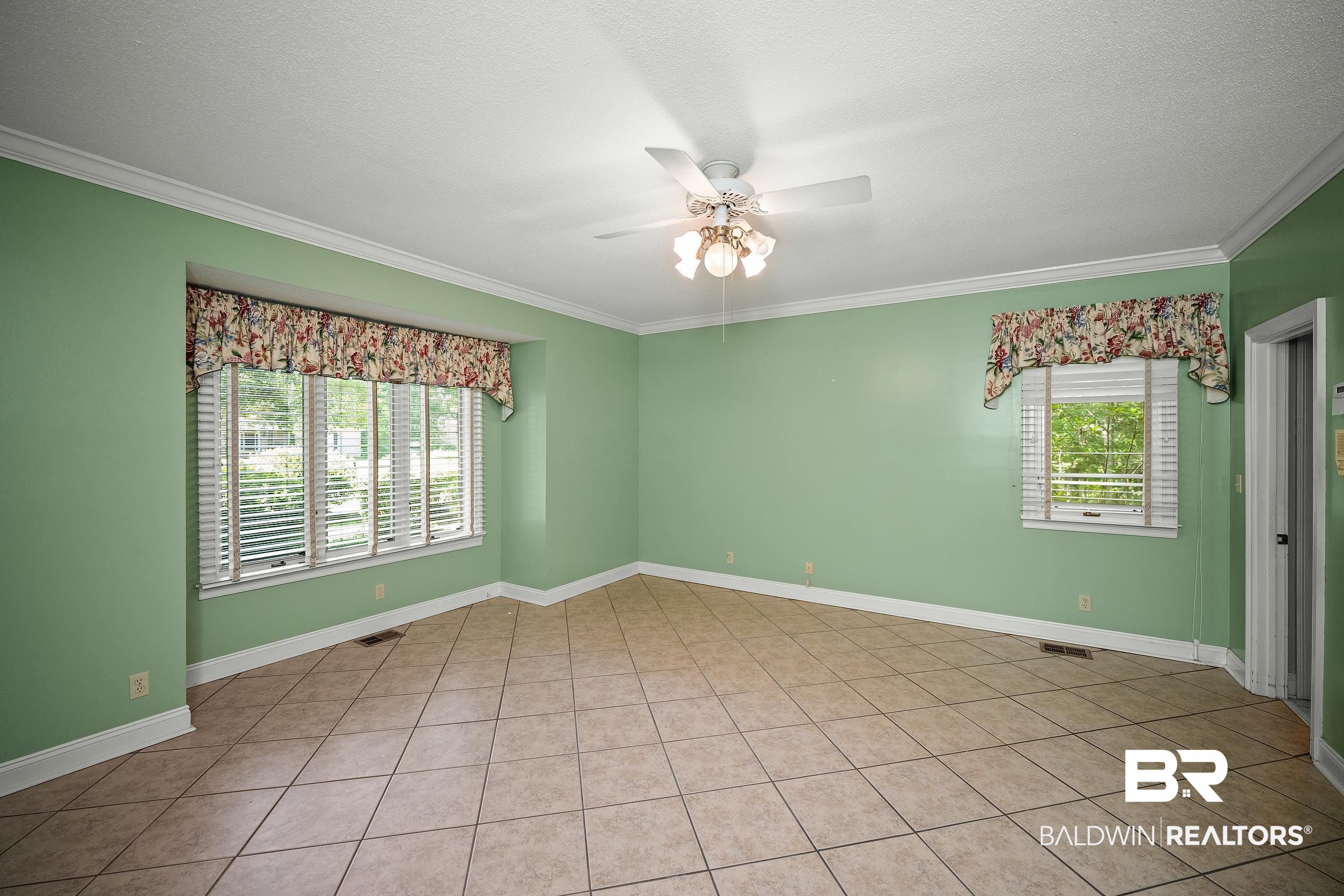 329 Norwood Road Monroeville, AL 36460 - Photo 18 of 49 Spacious room featuring tile flooring, white crown molding, and a ceiling fan with light fixture